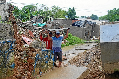 Habitantes evacuan sus viviendas luego del deslizamiento de tierra ocurrido después de varios días de intensas lluvias en esa población.