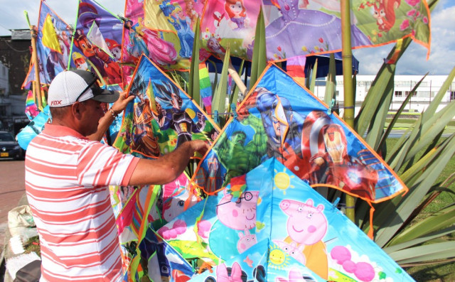 José Octavio acomoda sus cometas en su puesto. Las ventas han sido pocas, dice, pues hacen falta los tradicionales festivales para incentivar el comercio y la recreación. 