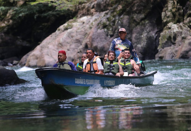 Las lanchas navegan el río La Miel con turistas que quieren ver las cascadas y sacarse una foto.