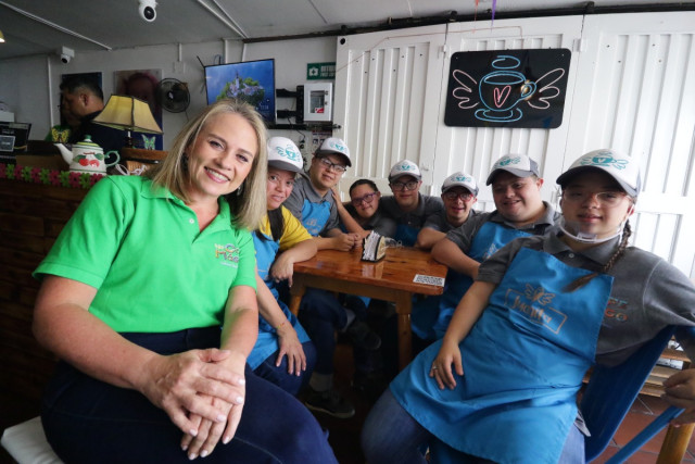 Alejandra Gómez junto a siete empleados de Café Mágico.