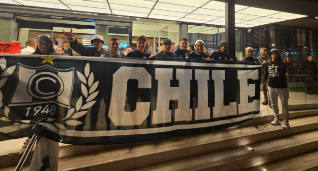 Hinchas del Once Caldas posaron con los jugadores con el trapo del filial Honor Chile, de la barra Holocausto Norte.