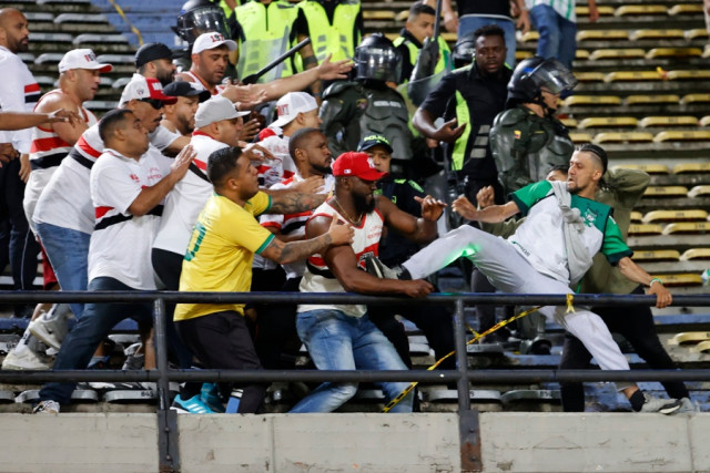 Un hincha (d) de Nacional se enfrenta a hinchas de Sao Paulo este martes, luego del partido de los octavos de final de la Copa Libertadores entre Atlético Nacional y Sao Paulo en el estadio Atanasio Girardot en Medellín (Colombia).