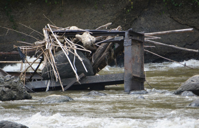 Piedras y troncos arrastrados por la corriente del río Cauca quedaron atrapados entre los hierros retorcidos de los vestigios del puente. Piedras y troncos arrastrados por la corriente del río Cauca quedaron atrapados entre los hierros retorcidos de los vestigios del puente.