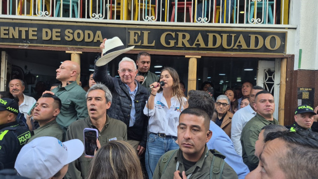 Rodeado por una multitud que llenaba la cuadra frente a la Fuente de Soda El Graduado, el expresidente se subió a un taburete para elogiar a su candidata Paloma Valencia.