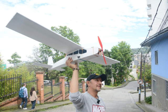 Julián Andrés Gómez Meneses prueba uno de sus aviones radiocontrolados terminados frente a su taller de Aeroconstructores Aeromodelismo, donde se construyen y reparan aeronaves a escala.