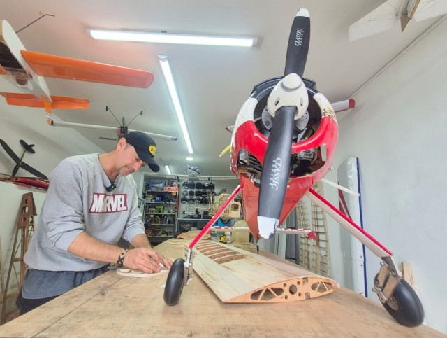 Julián Gómez trabaja en su taller de Aeroconstructores Aeromodelismo, rodeado de aeronaves a escala que él mismo enseña a construir desde cero.