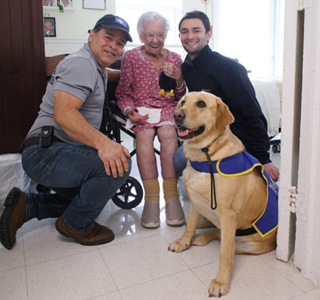 Juan Sebastián Montoya, en su voluntariado, junto a su padre, Juan Carlos Montoya, quien lo inspiró a seguir sus pasos; la labradora Matilda, y la paciente Bilma.
