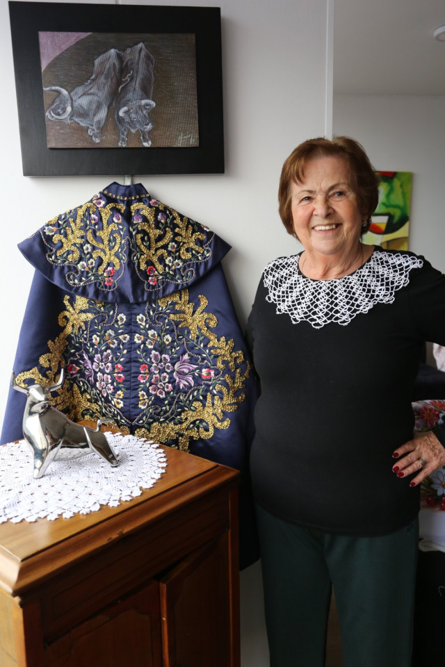 Ginna junto a uno de los capotes de paseillo que ha bordado.