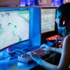 Mujer juega videojuegos en un computador. 