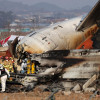 Bomberos trabajan en los restos del avión Jeju Air en el Aeropuerto Internacional de Muan. Las autoridades elevaron a 179 la cifra oficial de muertos.