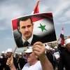 Un manifestante con una fotografía del presidente sirio, Bachar Al Assad, en la localidad drusa de Ein Qiniya. 