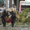 Integrantes de la Policía Nacional trasladan un cilindro tras una explosión en inmediaciones de la Escuela Militar de Aviación Marco Fidel Suárez este jueves, en Cali (Colombia). Al menos cinco personas murieron y 36 resultaron heridas por un atentado perpetrado con un camión bomba.