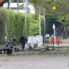 Integrantes de la Policía Nacional y Militares inspeccionan la zona del atentado tras una explosión en inmediaciones de la Escuela Militar de Aviación Marco Fidel Suárez este jueves, en Cali (Colombia).