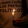 Una persona sostiene una vela en una vigilia frente al centro penitenciario Rodeo I este viernes, en Zamora estado de Miranda (Venezuela). 