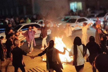 Un grupo de mujeres baila y quema sus velos durante una protesta nocturna en Bandar Abbas, en el suroeste de Irán.