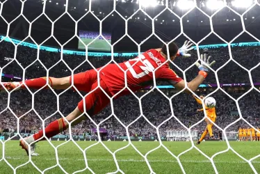 El portero Emiliano Martínez de Argentina ataja el penalti de Virgil van Dijk de los Países Bajos en la tanda de penales durante el partido de fútbol de cuartos de final de la Copa Mundial de la FIFA 2022 entre los Países Bajos y Argentina en el Estadio Lusail en Lusail, Qatar