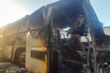 Fotografía cedida por Relaciones Públicas del Cuerpo de Bomberos de Panamá donde se ven bomberos mientras trabajan para apagar un incendio en un bus que trasladaba a 57 migrantes, en la carretera panamericana.