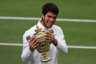 Carlos Alcaraz de España celebra con su trofeo después de ganar su último partido individual masculino contra Novak Djokovic de Serbia en el Campeonato de Wimbledon, en Gran Bretaña.