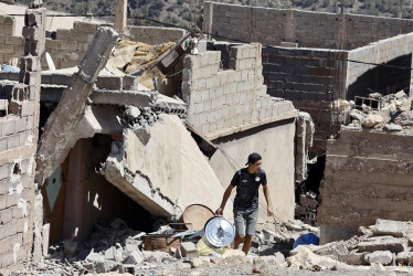 Un joven camina entre ruinas del terremoto en Moulay Brahim, al sur de Marrakesh, Marruecos.