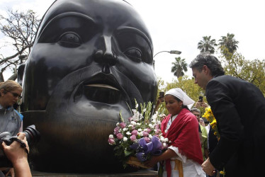 El alcalde de Medellín, Daniel Quintero, coloca ofrendas florales en la escultura "Cabeza" del maestro Fernando Botero durante un homenaje tras su fallecimiento, en la Plaza Botero en Medellín. 
