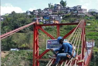 Un obrero le hace mantenimiento a los tensores del puente Olivares.