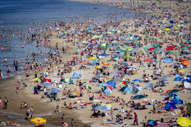 Cientos de bañistas se refrescan en la playa en Scheveningen, Países Bajos.