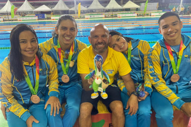 El equipo ganador de la medalla de bronce con su entrenador Andrey Parra (centro).