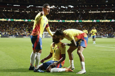 El delantero de la selección de Colombia John Córdoba (c) celebra su gol, primero del equipo, durante el partido amistoso que las selecciones de fútbol de Colombia y Rumanía disputan hoy martes en el estadio Metropolitano, en Madrid.
