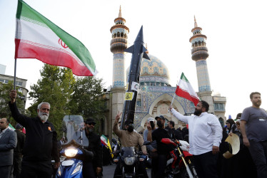 Un iraní porta un simulacro de misil durante una celebración tras el ataque de Irán a Israel, en la plaza Palestina, en Teherán, Irán, el 15 de abril de 2024.