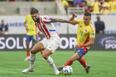Rafael Santos Borré se disputa la pelota con el defensor paraguayo Omar Alderete.