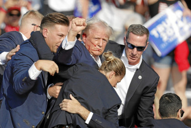 Foto | EFE | LA PATRIA  El expresidente de Estados Unidos Donald Trump rodeado por personal de seguridad tras el atentado que sufrió durante un encuentro de campaña en Butler, Pensilvania. El candidato republicano fue herido en la oreja derecha.
