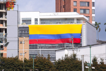 La bandera colombiana se ve en diferentes partes de la ciudad. La gente desde ya en modo selección. En la imagen se observa el edificio de Susuerte con la bandera gigante de Colombia. 