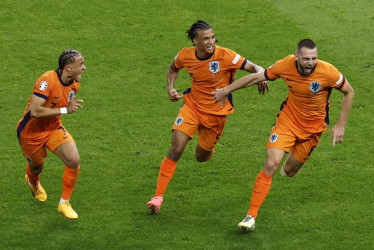 Stefan de Vrij (D) celebra con sus compañeros Nathan Ake (C) and Xavi Simons (I) el gol del empate. 