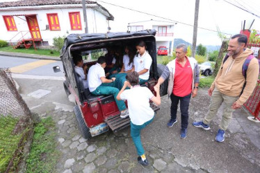 Fotos I Luis Fernando Trejos I LA PATRIA  El conductor Ramiro López ayuda a estudiantes a subir a su campero para el viaje de la Cuchilla del Salado, directo a la Feria del Libro en la U. de Caldas. Los acompaña el profesor Juan Carlos González, líder de la iniciativa. 