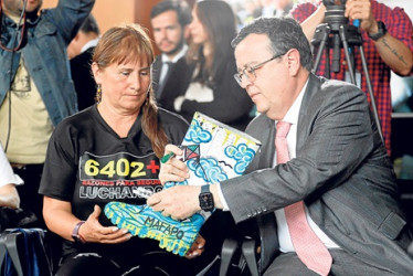 Foto | EFE | LA PATRIA El presidente de la Jurisdicción Especial para la Paz (JEP), Alejandro Ramelli, entrega una bota intervenida artísticamente a Jackeline Castillo, presidenta de Mafapo, que simboliza el dolor de las ejecuciones extrajudiciales.