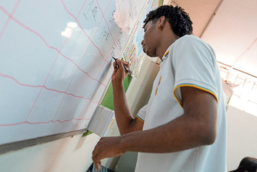 Un estudiante resuelve una actividad en el tablero. 