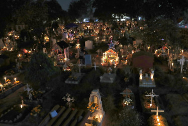 Familiares y amigos visitan a sus fieles difuntos la madrugada de este viernes en el panteón comunal San Gregorio Atlapulco, en la Ciudad de México (México). 