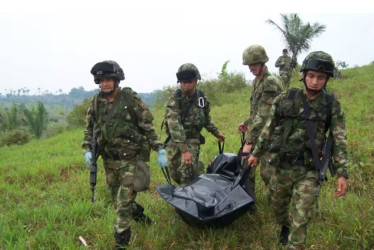 Miembros del Ejército Nacional cargan un cuerpo. 