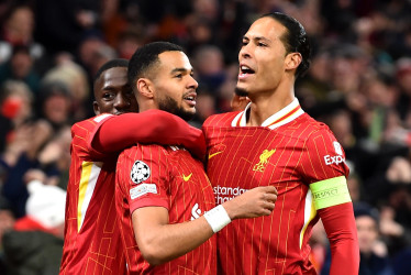 Cody Gakpo (c) celebra con sus compañeros Virgil van Dijk (d) e Ibrahima Konate tras anotar el 2-0 durante el partido de Liga de Campeones de la UEFA entre Liverpool y Real Madrid en Liverpool, Gran Bretaña.