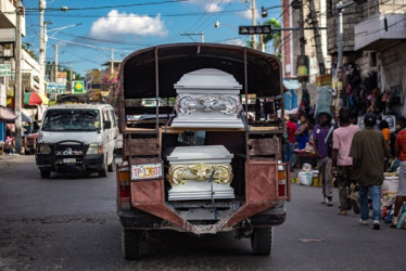 Foto | EFE | LA PATRIA  En vehículos de transporte colectivo cargan los féretros con los muertos de la masacre. 