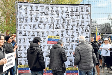 Foto | EFE | LA PATRIA Un cartel muestra fotografías de presos políticos en Venezuela durante la manifestación de opositores políticos venezolanos ayer, en Madrid.