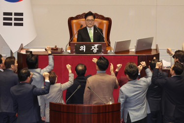 Diputados del gobernante Partido del Poder Popular (PPP) surcoreano protestan ante el presidente del Parlamento, Woo Won-shik, antes la votación de la moción de censura presentada por la oposición para destituir a Han Duck-soo, primer ministro y presidente en funciones desde hace apenas dos semanas. 