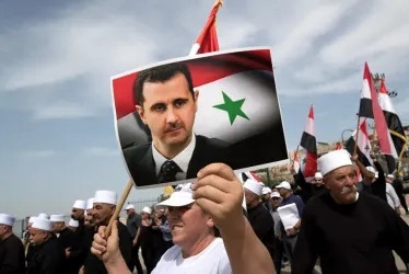 Un manifestante con una fotografía del presidente sirio, Bachar Al Assad, en la localidad drusa de Ein Qiniya. 