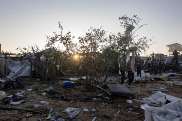 La gente inspecciona los daños después de un ataque aéreo israelí dirigido a un campamento de desplazados internos en la zona de Al-Mawasi, al oeste de Khan Yunis, en el sur de la Franja de Gaza, el 2 de enero de 2025, matando a diez palestinos, según el Hospital Nasser local.