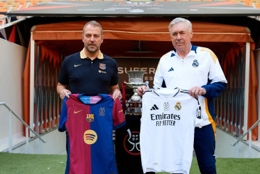 Los entrenadores del Real Madrid CF y el FC Barcelona, Carlo Ancelotti (d) y Hansi Flick (i), respectivamente, han posado este sábado junto al trofeo en el estadio Al Jawhara de Yeda. 