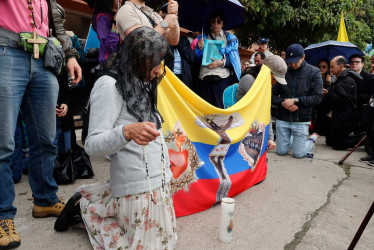 Personas rezan el rosario frente al hospital Fundación Santa Fe de Bogotá, por la pronta recuperación del senador Miguel Uribe, este sábado en Bogotá (Colombia). 