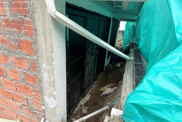 Esta es parte de la fachada de la casa que está cubierta con una lona verde. El inmueble se hundió aproximadamente 120 centímetros. 