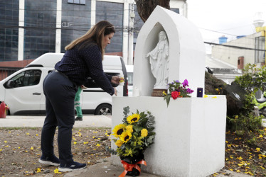 Una persona enciende una vela frente a un altar ubicado en el parque El Golfito del barrio Modelia, lugar del atentado contra el senador y precandidato presidencial Miguel Uribe Turbay, este lunes en Bogotá (Colombia). La Alcaldía de Bogotá anunció tres días de luto en honor a Uribe Turbay
