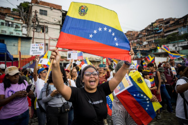Una persona sostiene una bandera de Venezuela en una manifestación este viernes, en Caracas (Venezuela). Simpatizantes del chavismo se movilizaron en comunidades de Venezuela para participar en la jornada de alistamiento de milicianos y reiterar su respaldo al presidente Nicolás Maduro ante lo que consideran "amenazas" de Estados Unidos
