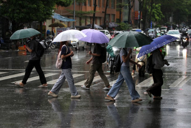 Personas con paraguas caminan bajo la lluvia en Hanoi (Vietnam).